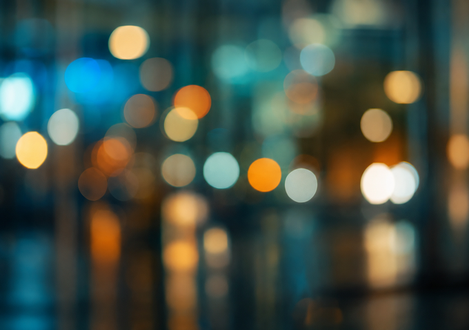 Abstract teal and amber city lights blurred into soft bokeh reflections.